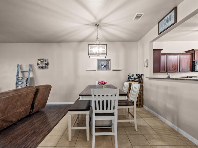 dining area featuring an inviting chandelier, baseboards, visible vents, and light tile patterned flooring