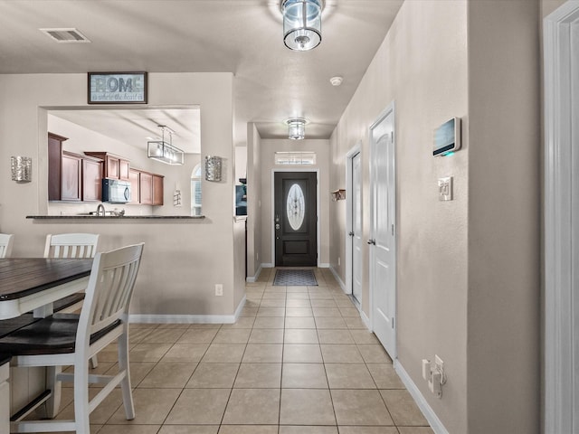 entryway with visible vents, baseboards, and light tile patterned floors