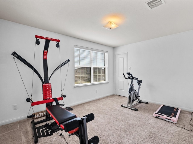 exercise area featuring baseboards, visible vents, and carpet flooring