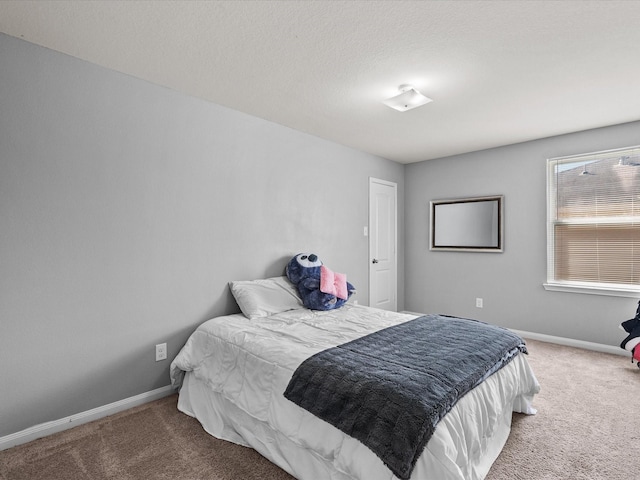 bedroom featuring carpet floors, baseboards, and a textured ceiling