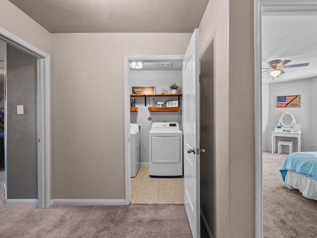 clothes washing area with ceiling fan, light tile patterned flooring, light carpet, laundry area, and washer and dryer