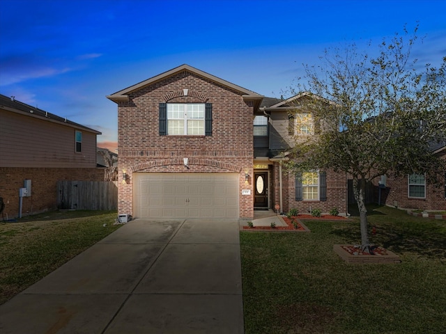 traditional-style home featuring concrete driveway, brick siding, a front yard, and fence