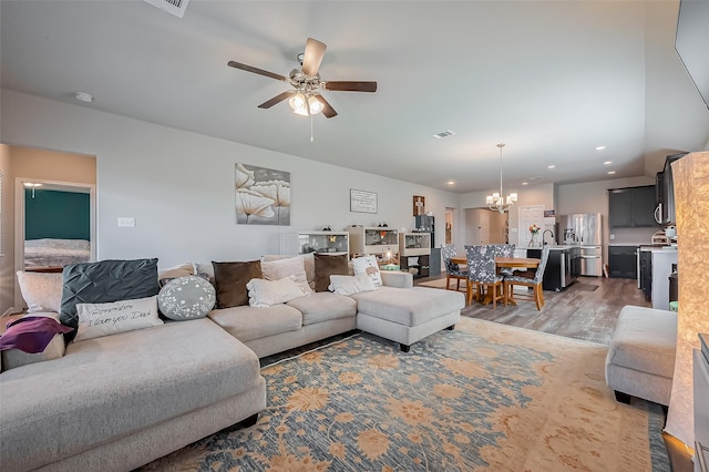 living area with ceiling fan with notable chandelier, light wood finished floors, visible vents, and recessed lighting