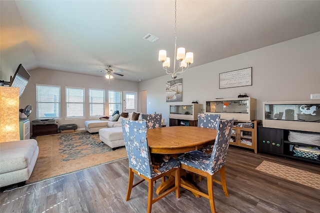 dining space with visible vents, wood finished floors, and ceiling fan with notable chandelier