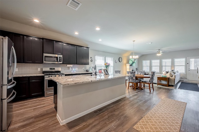 kitchen featuring appliances with stainless steel finishes, visible vents, dark wood-style floors, and tasteful backsplash