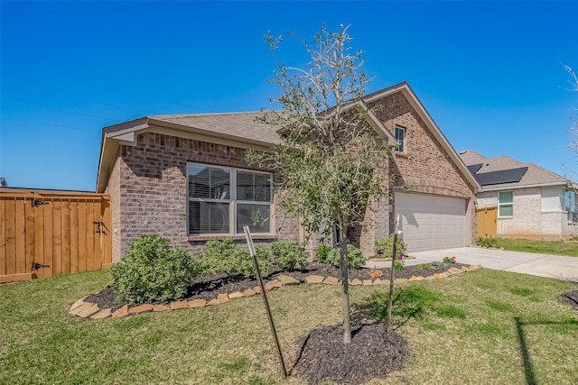 view of front of house featuring brick siding, an attached garage, fence, driveway, and a front lawn