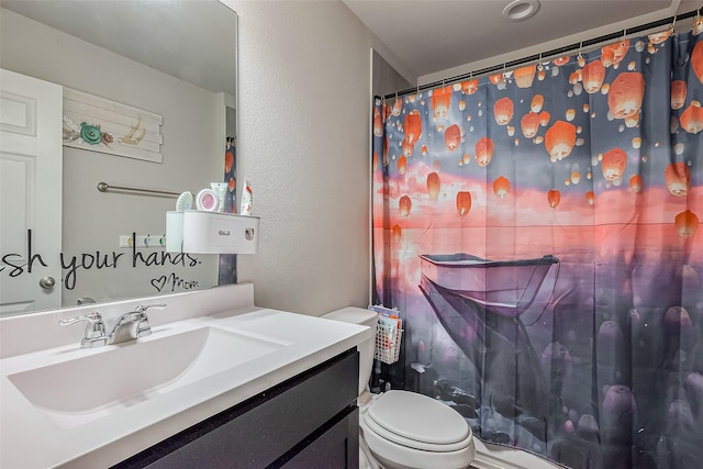 full bath with a textured wall, vanity, toilet, and a shower with curtain