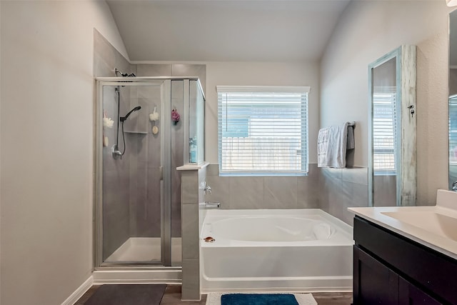 bathroom with a stall shower, lofted ceiling, and a bath