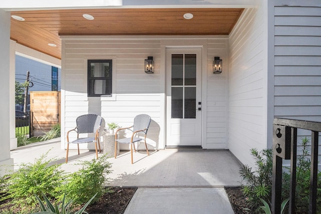 view of exterior entry featuring covered porch