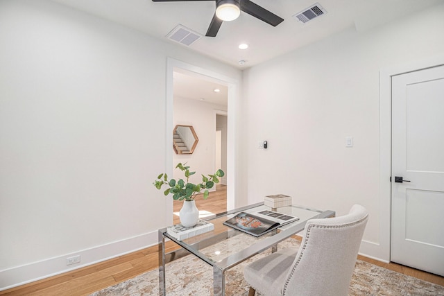 home office with light wood-type flooring, baseboards, visible vents, and a ceiling fan