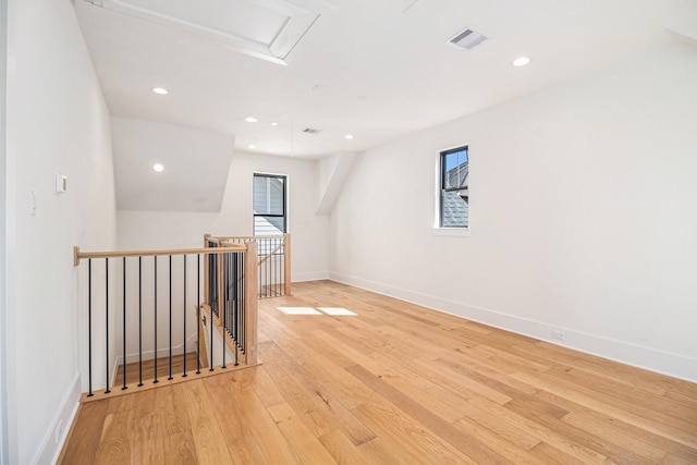 empty room with baseboards, light wood-style flooring, visible vents, and a wealth of natural light