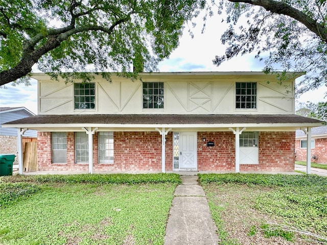 view of front facade featuring stucco siding, a front lawn, and brick siding