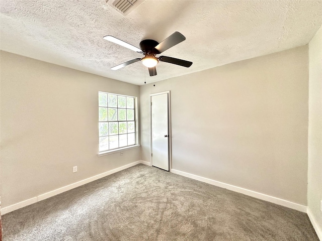 spare room featuring a ceiling fan, baseboards, visible vents, and carpet flooring