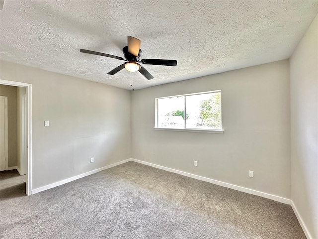 carpeted spare room with a ceiling fan, a textured ceiling, and baseboards