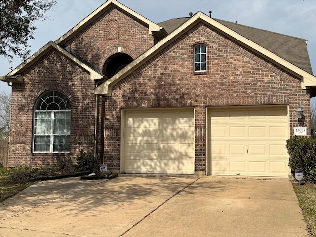 view of front of property with concrete driveway, an attached garage, and brick siding