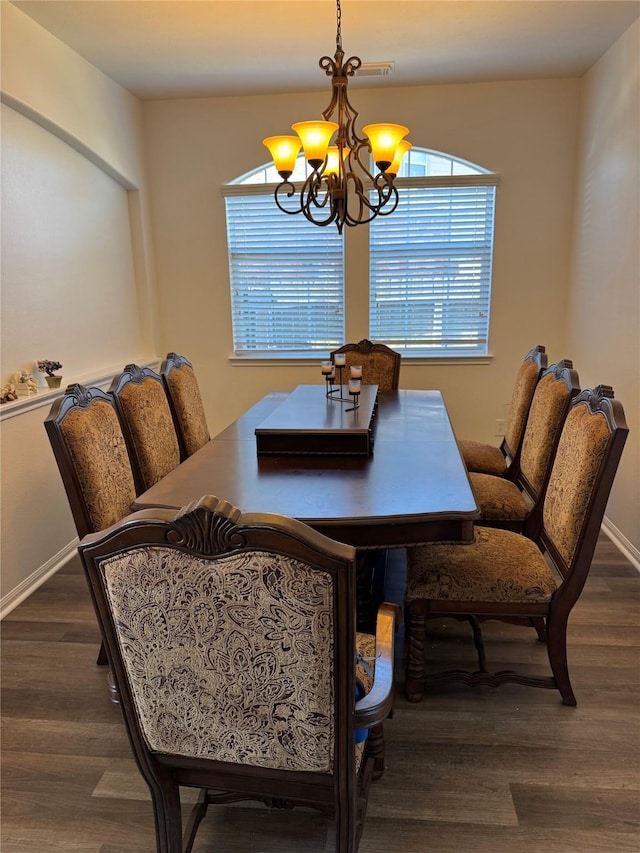 dining area featuring baseboards, a notable chandelier, and wood finished floors