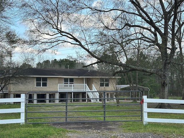 view of front of house featuring a fenced front yard, a detached carport, a gate, and a front yard