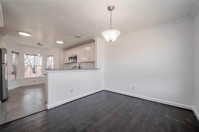 kitchen featuring tasteful backsplash, baseboards, white cabinets, appliances with stainless steel finishes, and dark wood-style flooring