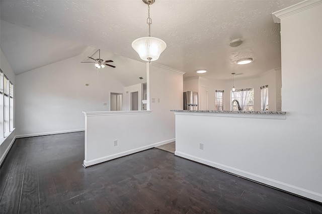 unfurnished room with baseboards, ceiling fan, dark wood-style flooring, vaulted ceiling, and a textured ceiling