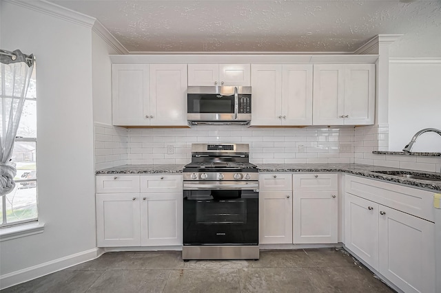 kitchen with stainless steel appliances, backsplash, ornamental molding, white cabinetry, and a sink