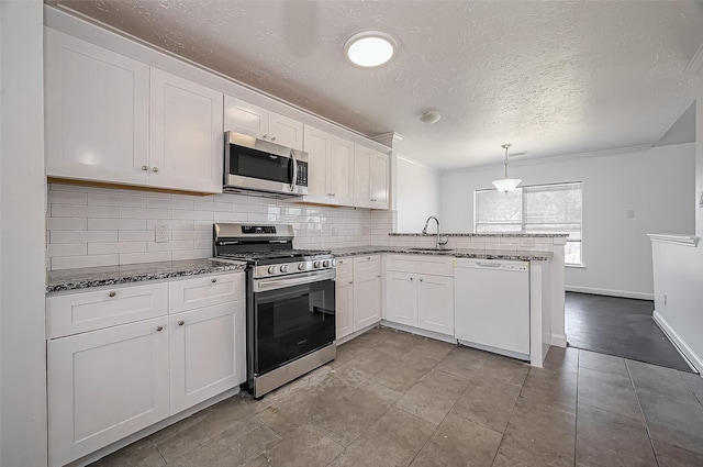 kitchen with stainless steel appliances, tasteful backsplash, white cabinetry, a sink, and a peninsula