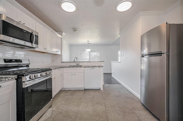 kitchen with a peninsula, appliances with stainless steel finishes, a sink, and white cabinetry