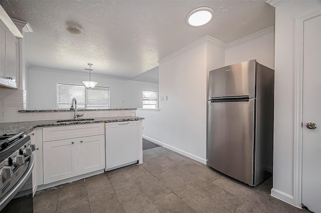 kitchen featuring stainless steel appliances, backsplash, a sink, dark stone countertops, and a peninsula