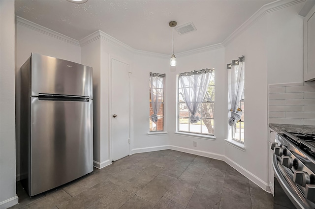 kitchen featuring crown molding, visible vents, decorative backsplash, appliances with stainless steel finishes, and baseboards