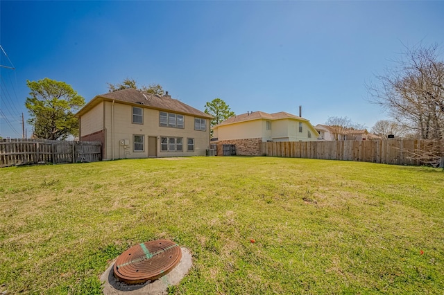 exterior space with central AC unit, a lawn, and a fenced backyard