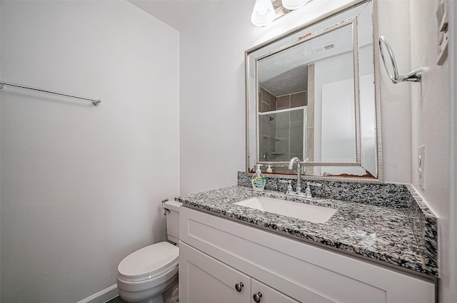 bathroom featuring visible vents, baseboards, toilet, vanity, and a shower stall