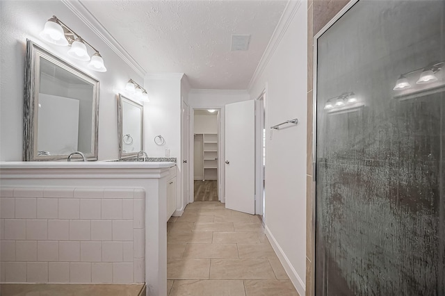 bathroom with a walk in closet, visible vents, ornamental molding, a textured ceiling, and tile patterned floors