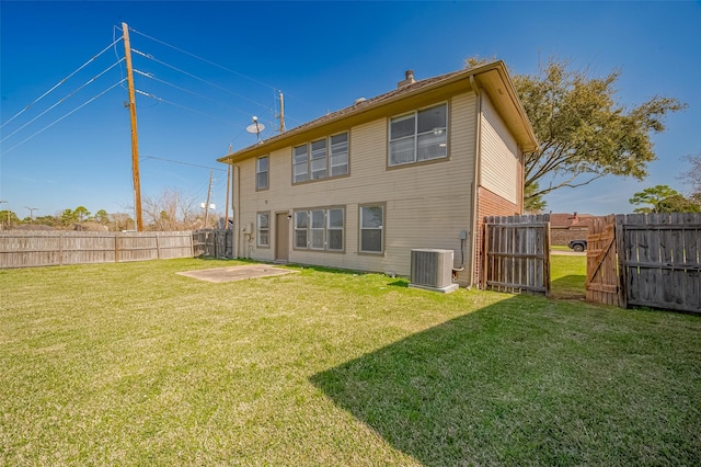 rear view of property featuring a fenced backyard, a lawn, cooling unit, and a patio