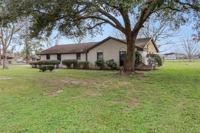 view of side of home featuring a yard and brick siding