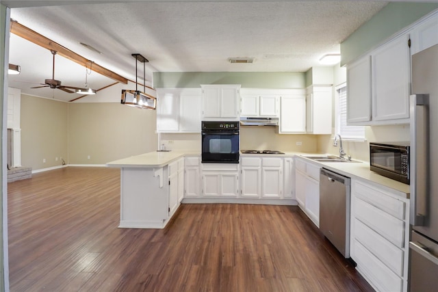 kitchen with under cabinet range hood, a peninsula, a sink, black appliances, and a glass covered fireplace