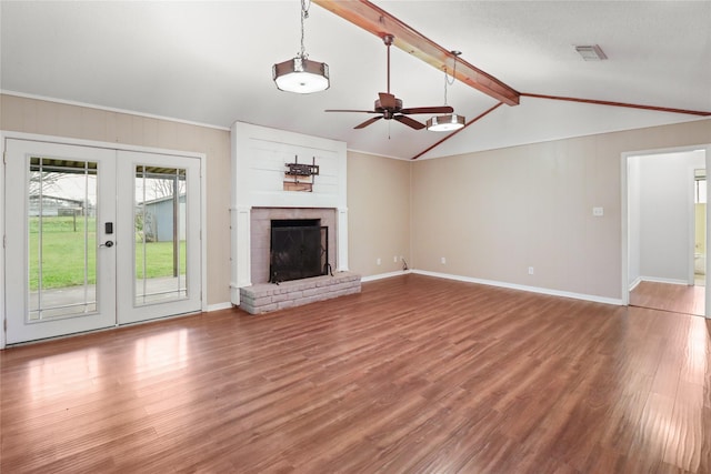 unfurnished living room featuring visible vents, a fireplace with raised hearth, wood finished floors, vaulted ceiling with beams, and french doors