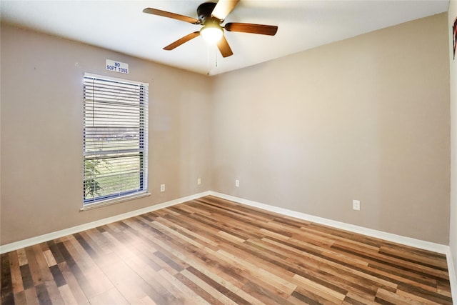 unfurnished room with wood finished floors, a ceiling fan, and baseboards