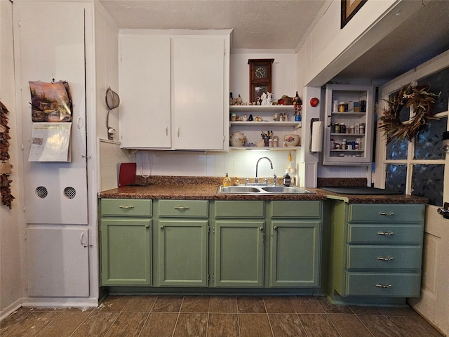 kitchen with a sink, white cabinets, backsplash, open shelves, and green cabinetry