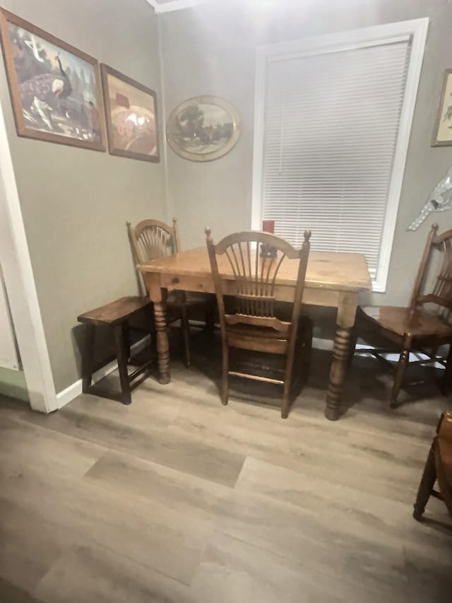 dining area with light wood-type flooring and baseboards