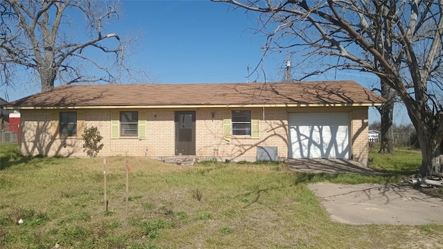 back of house featuring a garage, brick siding, and a lawn