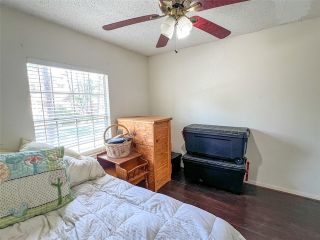 bedroom featuring a textured ceiling, ceiling fan, wood finished floors, and baseboards