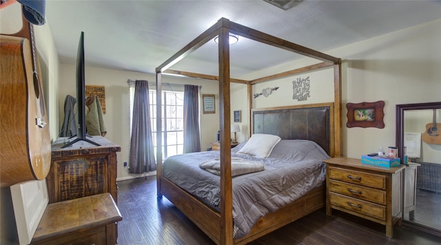 bedroom featuring visible vents and dark wood finished floors