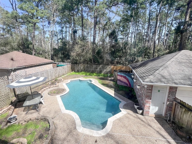 view of swimming pool with a fenced backyard, a fenced in pool, and a patio