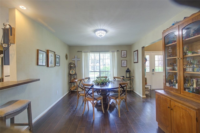 dining area featuring dark wood-type flooring and baseboards