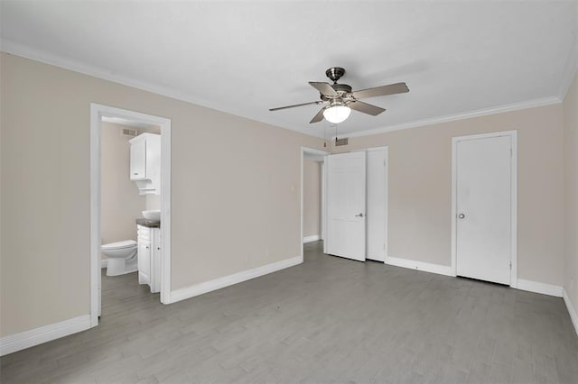 unfurnished bedroom with crown molding, baseboards, and wood finished floors