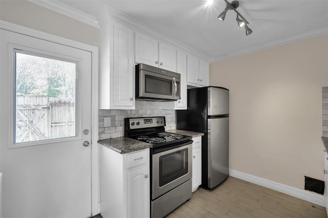 kitchen with decorative backsplash, appliances with stainless steel finishes, ornamental molding, light wood-type flooring, and white cabinetry