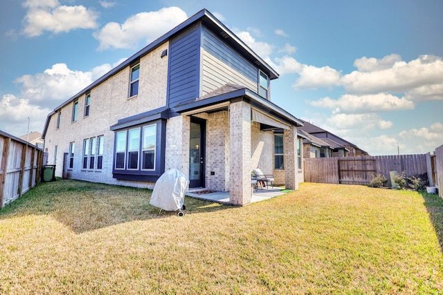 rear view of house with a patio area, a fenced backyard, a lawn, and brick siding