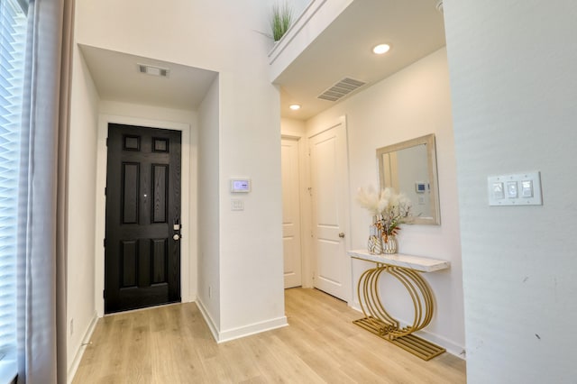 foyer entrance featuring light wood-style flooring, recessed lighting, visible vents, and baseboards