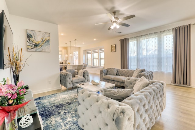 living area with recessed lighting, visible vents, ceiling fan, light wood-type flooring, and baseboards