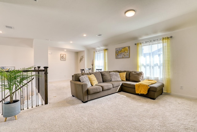 carpeted living room featuring visible vents, plenty of natural light, and baseboards