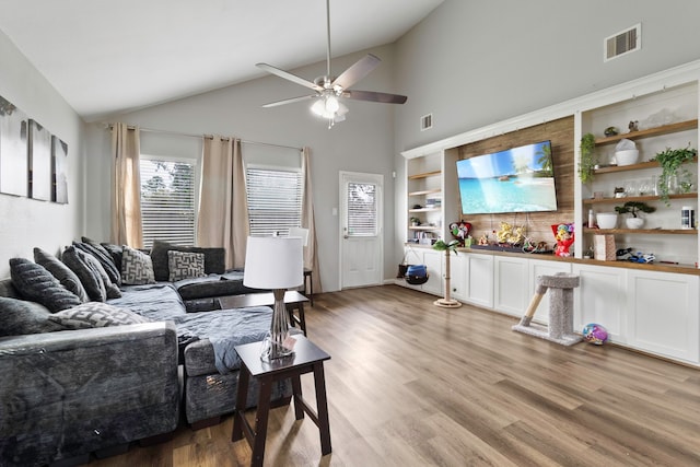 living room with ceiling fan, light wood finished floors, lofted ceiling, and visible vents